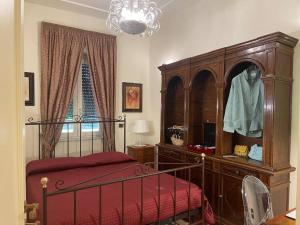 ein Schlafzimmer mit einem Bett, einer Kommode und einem Fenster in der Unterkunft Fancy House in Reggio di Calabria