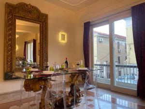 comedor con mesa de cristal y espejo en Fancy House, en Reggio Calabria