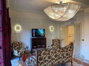 sala de estar con sofá, sillas y TV en Fancy House, en Reggio Calabria