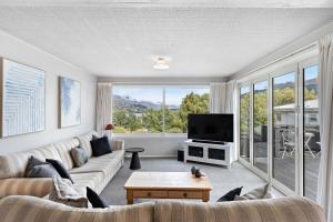 uma sala de estar com um sofá e uma televisão em Lake and Mountain view living em Queenstown