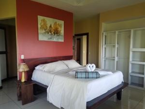 a bedroom with two beds and a red wall at House Susan in San Pedrillo