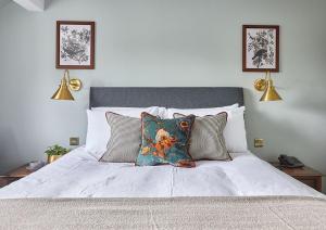a white bed with two pillows on it at The New Inn Heckfield in Hook