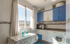 una cocina con armarios azules y una mesa frente a una ventana en 1 Bedroom Pet Friendly Apartment In Puente De Genave, en Puente de Génave