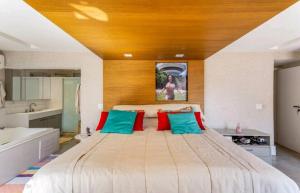 een slaapkamer met een groot bed met rode en blauwe kussens bij Apartamento Luxuoso Frente Mar e MAC in Niterói