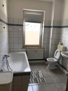baño con bañera, aseo y ventana en Monteurwohnung in Leipzig en Leipzig