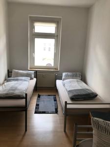 2 camas en una habitación con ventana en Monteurwohnung in Leipzig en Leipzig