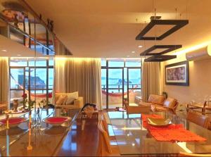 een woonkamer met veel meubilair en ramen bij Apartamento Luxuoso Frente Mar e MAC in Niterói