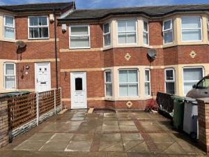 a brick house with a car parked in front of it at Tivoli villas in New Brighton