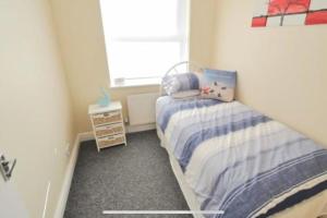 a small bedroom with a bed and a window at Tivoli villas in New Brighton