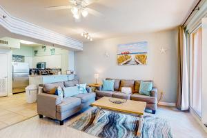 a living room with two couches and a table at Shores of Panama 2310 in Panama City Beach