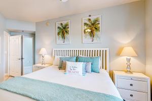 a bedroom with a large bed with blue pillows at Shores of Panama 2310 in Panama City Beach