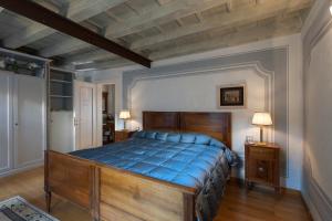 Un dormitorio con una gran cama de madera con sábanas azules en Domus Nova Palace - Italian Homing, en Verona