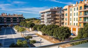 Vistas al mar de una calle con árboles y edificios en Apartamento playa Cambrils Torresol 2, en Cambrils