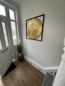 a hallway with a white wall with a gold fan at Watford Road House Liverpool in Liverpool