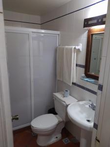 La salle de bains blanche est pourvue de toilettes et d'un lavabo. dans l'établissement HOTEL COLONIAL MATAMOROS, à Matamoros