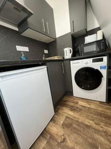uma cozinha com uma máquina de lavar roupa e um micro-ondas em 008- S2Premium location studio apartment central London em Londres