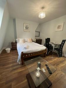 um quarto com uma cama e uma mesa com controlo remoto em 008- S2Premium location studio apartment central London em Londres