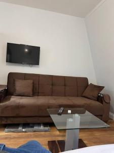 a living room with a brown couch and a table at 008- S2Premium location studio apartment central London in London