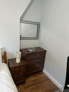 a bedroom with a mirror and a wooden dresser at 008- S2Premium location studio apartment central London in London