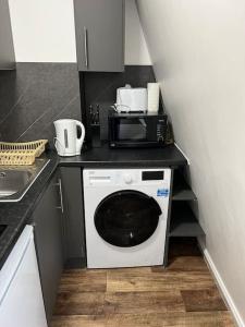 uma pequena cozinha com um micro-ondas e uma máquina de lavar roupa em 008- S2Premium location studio apartment central London em Londres
