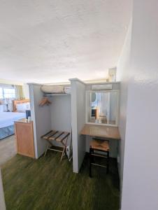Habitación con escritorio, cama y espejo. en Seaway Inn, en Santa Cruz