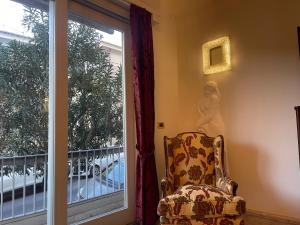 Habitación con silla y ventana con vistas. en Fancy House, en Reggio Calabria