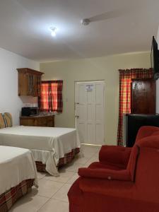 a living room with two beds and a couch at Comfy Stay in Jamaica -Enjoy 7 Miles of White Sand Beach! villa in Negril