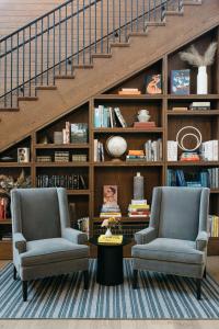 twee stoelen en een tafel in een kamer met een trap bij The Study at the University of Chicago in Chicago