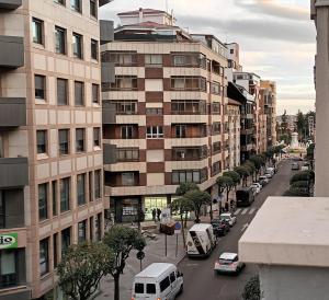 a city street with cars and a tall building at Apartamento Roma 8 in León