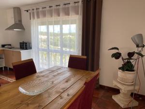 une table à manger avec des chaises et une grande fenêtre dans l'établissement Casa da Rosa, à Carvalheira Grande