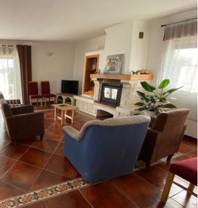 sala de estar con silla azul y chimenea en Casa da Rosa, en Carvalheira Grande