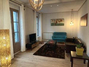 a living room with a blue couch and a tv at Apartamento Roma 8 in León