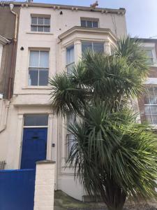 スカーバラにあるGranby House Holiday Apartments, Apartment 2, Formerly Sandy Palmsの青い扉とヤシの木のある家