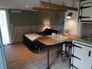 a bedroom with a bed and a table and a kitchen at Studio pour 2 in Montain