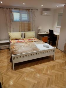 a bedroom with a bed and a wooden floor at Apartments Nena in Split