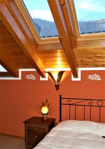 a bedroom with a bed and a ceiling with skylights at Narciso B&B Valbrona in Valbrona