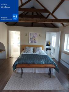 a bedroom with a large bed with a blue comforter at Loft in Bungay in Bungay