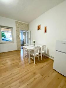 a white dining room with a white table and chairs at Apartmán Markéta in Bystrzyca
