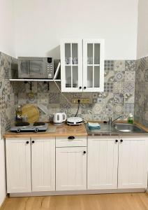 a kitchen with white cabinets and a microwave at Apartmán Markéta in Bystrzyca