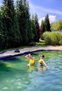 Due donne in acqua in una piscina di Apartmán Markéta a Bystrzyca