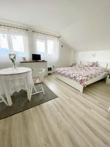 a bedroom with two beds and a table and a desk at Ubytovani v Beskydech in Bystrzyca