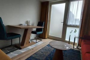 een woonkamer met een tafel en stoelen en een raam bij Dajan in Almere