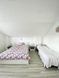 two beds in a bedroom with white walls and wooden floors at Ubytovani v Beskydech in Bystrzyca