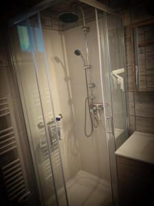 une salle de bain avec une douche avec une porte vitrée dans l'établissement Maison à 300 m de la plage., à La Cotinière