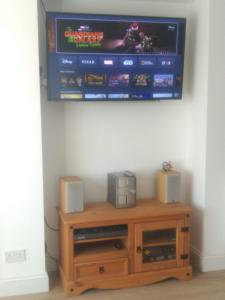 a television on a wall with a video game on it at Cheltenham - 3 Bed Newly Renovated With Parking in Cheltenham