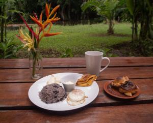 a plate of food and a cup of coffee on a table at Los Chocuacos. in Guácimo