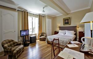 ein Hotelzimmer mit einem Bett und einem Schreibtisch in der Unterkunft Le Vieux Logis in Trémolat
