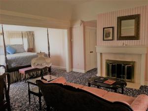 a living room with a bed and a fireplace at Mendocino Hotel & Garden in Mendocino