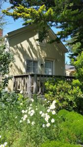 ein Haus mit einem Zaun und Blumen davor in der Unterkunft Mendocino Hotel & Garden in Mendocino