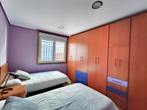 1 dormitorio con 2 camas, armarios y ventana en Apartamento Maya - Playa de Laxe, en Laxe